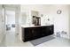 Bathroom with double sinks, dark cabinetry, full mirror, and tile flooring at 6230 Bravestar Ct, Las Vegas, NV 89141