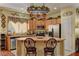 Charming kitchen featuring light wood cabinets, stainless steel appliances, and a central island with seating at 6329 Kitamaya St, North Las Vegas, NV 89031