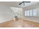 Bright living area with wood-look floors, stairs, and large window with shutter-style blinds at 6533 Sundown Heights Ave, Las Vegas, NV 89130