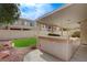 A spacious backyard features a covered patio, a built-in grill, and an artificial turf area at 775 Wigan Pier Dr, Henderson, NV 89002