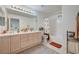 Well-lit bathroom featuring double sinks, shower over tub and tile flooring at 775 Wigan Pier Dr, Henderson, NV 89002