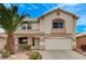 Inviting two-story home with a well-manicured front yard and attached two-car garage at 775 Wigan Pier Dr, Henderson, NV 89002