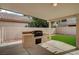 Built in grill and artificial turf are featured in this backyard patio at 775 Wigan Pier Dr, Henderson, NV 89002