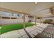 Wide angle of a covered patio with artificial turf and desert landscaping at 775 Wigan Pier Dr, Henderson, NV 89002
