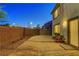 View of the backyard with block wall, gravel, and chairs outside of the sliding glass door at 7853 Bethel Heights Ln, Las Vegas, NV 89113