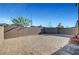 View of the gravel backyard featuring cinder block wall, shrubbery, and two chairs at 7853 Bethel Heights Ln, Las Vegas, NV 89113