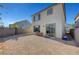 This gravel backyard is accented by a neutral colored stucco home with a sliding glass door at 7853 Bethel Heights Ln, Las Vegas, NV 89113