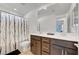 This bathroom features double sinks, modern cabinets, and neutral shower curtain at 7853 Bethel Heights Ln, Las Vegas, NV 89113