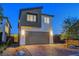 Exterior view of modern two-story home showing two-car garage, desert landscaping, and exterior lighting at 7853 Bethel Heights Ln, Las Vegas, NV 89113