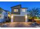 Exterior view of a two-story modern home with a two-car garage and desert landscaping at 7853 Bethel Heights Ln, Las Vegas, NV 89113