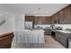 Stylish kitchen with stainless steel appliances, dark cabinets, a white quartz island, and bar stool seating at 7853 Bethel Heights Ln, Las Vegas, NV 89113