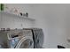 Functional laundry area with modern machines and convenient shelving at 7853 Bethel Heights Ln, Las Vegas, NV 89113