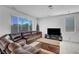 Cozy living room with a brown sectional, flat-screen TV, and large windows providing ample natural light at 7853 Bethel Heights Ln, Las Vegas, NV 89113
