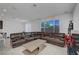 Bright living room featuring a large sectional sofa, neutral tile flooring, and a window offering natural light at 7853 Bethel Heights Ln, Las Vegas, NV 89113