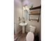 Cozy powder room with pedestal sink, oval mirror and wood shelves at 8186 Guadiano Ave, Las Vegas, NV 89113