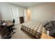 Inviting bedroom with a comfy plaid bed, and a workspace featuring an adaptable wooden desk at 8186 Guadiano Ave, Las Vegas, NV 89113