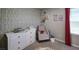 Bedroom featuring a dresser, rocker, and animal-themed wallpaper at 8186 Guadiano Ave, Las Vegas, NV 89113