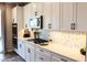 Modern kitchen with white cabinets, stainless steel appliances, and marble hexagon backsplash at 8186 Guadiano Ave, Las Vegas, NV 89113