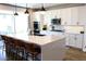 Bright kitchen with white cabinetry, stainless appliances, an island, and a sliding glass door to the outdoor patio at 8186 Guadiano Ave, Las Vegas, NV 89113