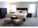 Spacious main bedroom with a comfortable bed, side tables, and chairs for additional seating at 8186 Guadiano Ave, Las Vegas, NV 89113
