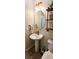 Close-up of a half bathroom featuring a pedestal sink, modern lighting, and rustic shelving at 8186 Guadiano Ave, Las Vegas, NV 89113