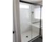 This updated shower has glass doors, a built-in seat, and modern fixtures at 8186 Guadiano Ave, Las Vegas, NV 89113