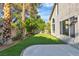 Serene backyard featuring an artificial lawn, mature trees, and a concrete patio at 8416 Kawala Dr, Las Vegas, NV 89128
