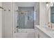 Stylish bathroom with a tub, gold fixtures, herringbone tiled shower, and sleek white vanity at 8416 Kawala Dr, Las Vegas, NV 89128