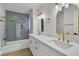 Elegant bathroom showcasing a double vanity, quartz countertops, and a glass-enclosed shower and tub at 8416 Kawala Dr, Las Vegas, NV 89128