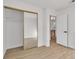 Bedroom with mirror closet doors, light walls, and wood-style laminate flooring at 8416 Kawala Dr, Las Vegas, NV 89128
