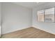 Spare bedroom with tile roof view, neutral walls, and wood-style laminate flooring at 8416 Kawala Dr, Las Vegas, NV 89128