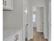 Hallway with access to bathroom, featuring white cabinetry with gold handles and hardwood floors at 8416 Kawala Dr, Las Vegas, NV 89128