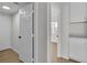 Hallway with white door, neutral walls, and wood-style laminate flooring at 8416 Kawala Dr, Las Vegas, NV 89128