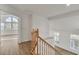 Well-lit hallway with hardwood floors, offering views of the living area and neighborhood from the upper level at 8416 Kawala Dr, Las Vegas, NV 89128