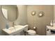 Stylish powder room featuring modern fixtures, pedestal sink, round mirror, and decorative wallpaper for guests at 9136 Eagle Ford St, Las Vegas, NV 89113