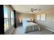 Inviting bedroom with large windows, a ceiling fan, and a comfortable upholstered bed at 9136 Eagle Ford St, Las Vegas, NV 89113