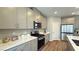 Modern kitchen with stainless steel appliances, gray cabinets and a quartz countertop at 9136 Eagle Ford St, Las Vegas, NV 89113
