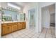 Bright bathroom featuring a double sink vanity, shower with glass door, and tile flooring at 9717 Buckhorn Dr, Las Vegas, NV 89134