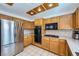Kitchen with stainless steel appliances, oak cabinets, white countertops, and tile flooring at 9717 Buckhorn Dr, Las Vegas, NV 89134