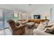 Inviting living room with neutral tones, comfortable seating, large windows, and a modern television at 9717 Buckhorn Dr, Las Vegas, NV 89134