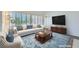 Bright living room with a white couch, plush arm chair, a blue rug, and plantation shutters at 9717 Buckhorn Dr, Las Vegas, NV 89134