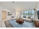 Staged living room features plantation shutters, a blue rug, and a white couch and arm chair at 9717 Buckhorn Dr, Las Vegas, NV 89134