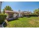 Landscaped backyard featuring a well-maintained lawn, patio area, and lush greenery for outdoor enjoyment at 2821 Whispering Wind Dr, Las Vegas, NV 89117
