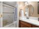 Bathroom featuring a single sink, round mirror, and a shower with seat at 2821 Whispering Wind Dr, Las Vegas, NV 89117