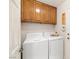 Functional laundry room features overhead cabinets and modern washer and dryer units for efficient laundry care at 2821 Whispering Wind Dr, Las Vegas, NV 89117