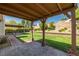 Covered brick patio with multiple seating areas, provides a versatile outdoor space for relaxation and entertainment at 2821 Whispering Wind Dr, Las Vegas, NV 89117