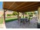 Covered brick patio with outdoor dining set, offers an inviting spot for al fresco meals and relaxation at 2821 Whispering Wind Dr, Las Vegas, NV 89117