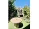Inviting backyard oasis featuring a stone table, lush greenery, and a charming tiered fountain at , Las Vegas, NV 89141