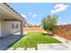 View of backyard with artificial grass, landscaping stones, and a small olive tree at 1000 Cetona Ct, Henderson, NV 89011