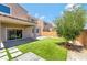 A view of the backyard showcasing artificial turf, pavers, and a young olive tree at 1000 Cetona Ct, Henderson, NV 89011